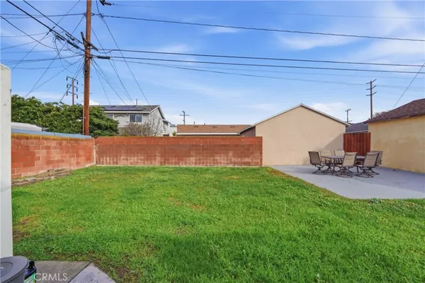 a view of a backyard with couches under an umbrella