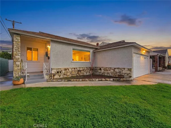 a front view of a house with patio and garden