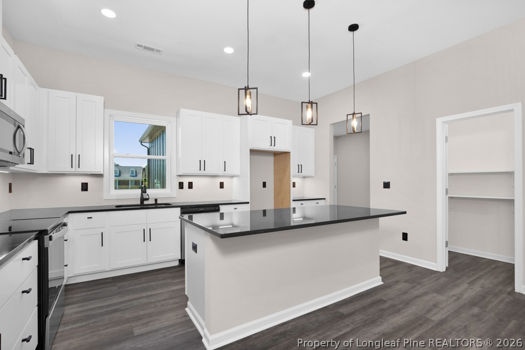 3025 Old Stage Road South Erwin, NC 28339 - Photo 15 of 50 a large kitchen with stainless steel appliances kitchen island granite countertop a sink a stove and a refrigerator