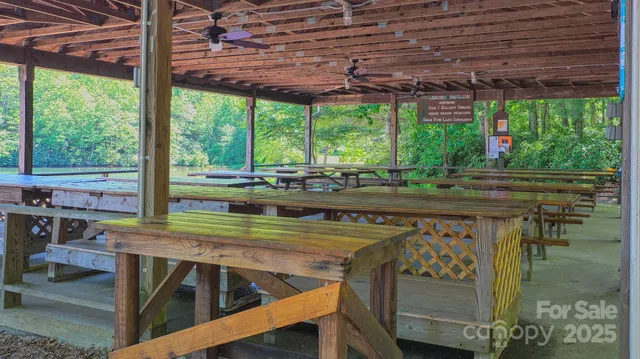 a view of a patio with table and chairs under an umbrella with a small yard