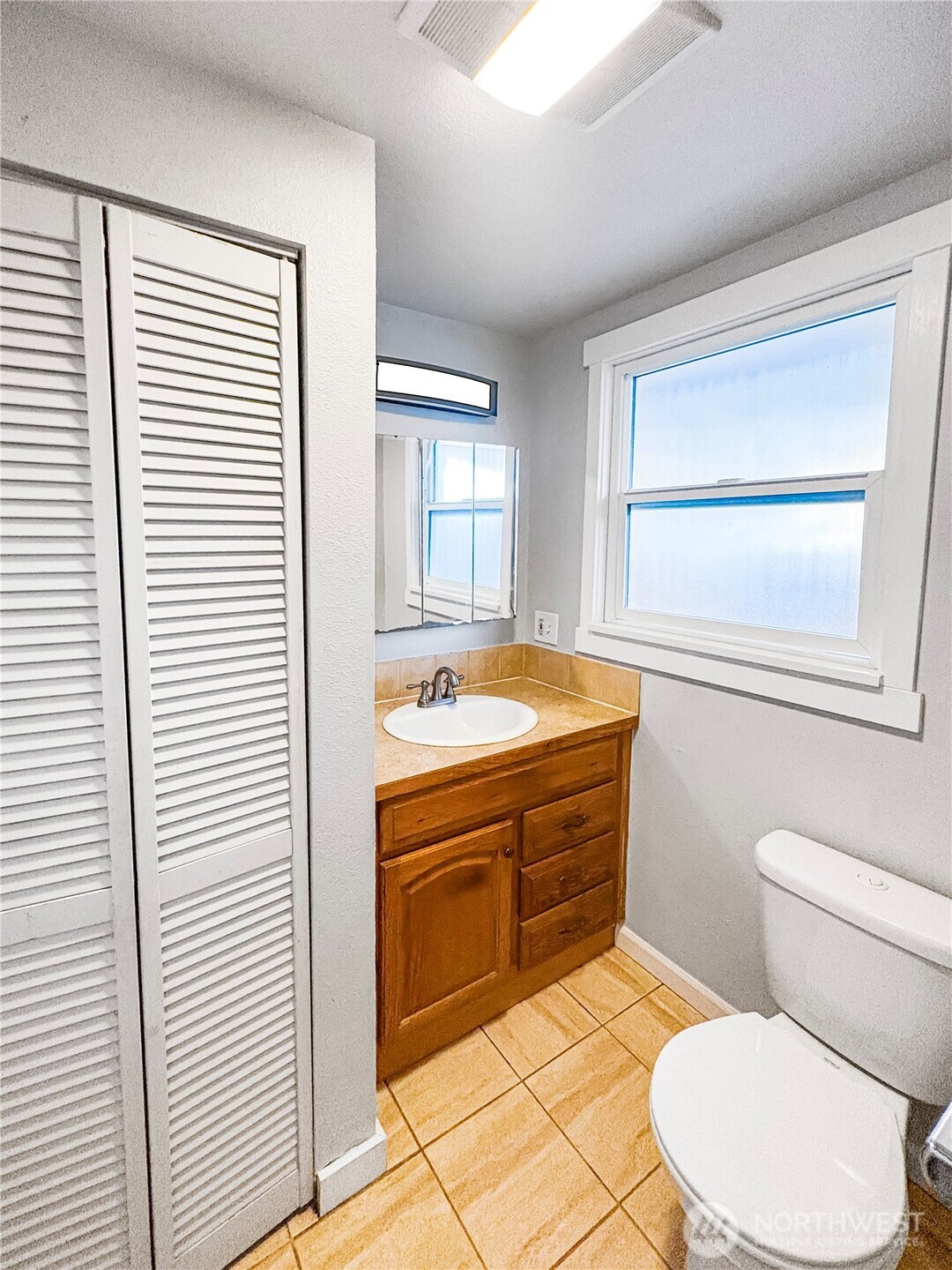 4908 236th Street Southwest Mountlake Terrace, WA 98043 - Photo 18 of 21 a bathroom with a sink a mirror and a toilet