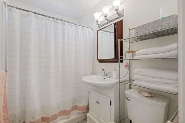 a bathroom with a sink a toilet and shower curtain