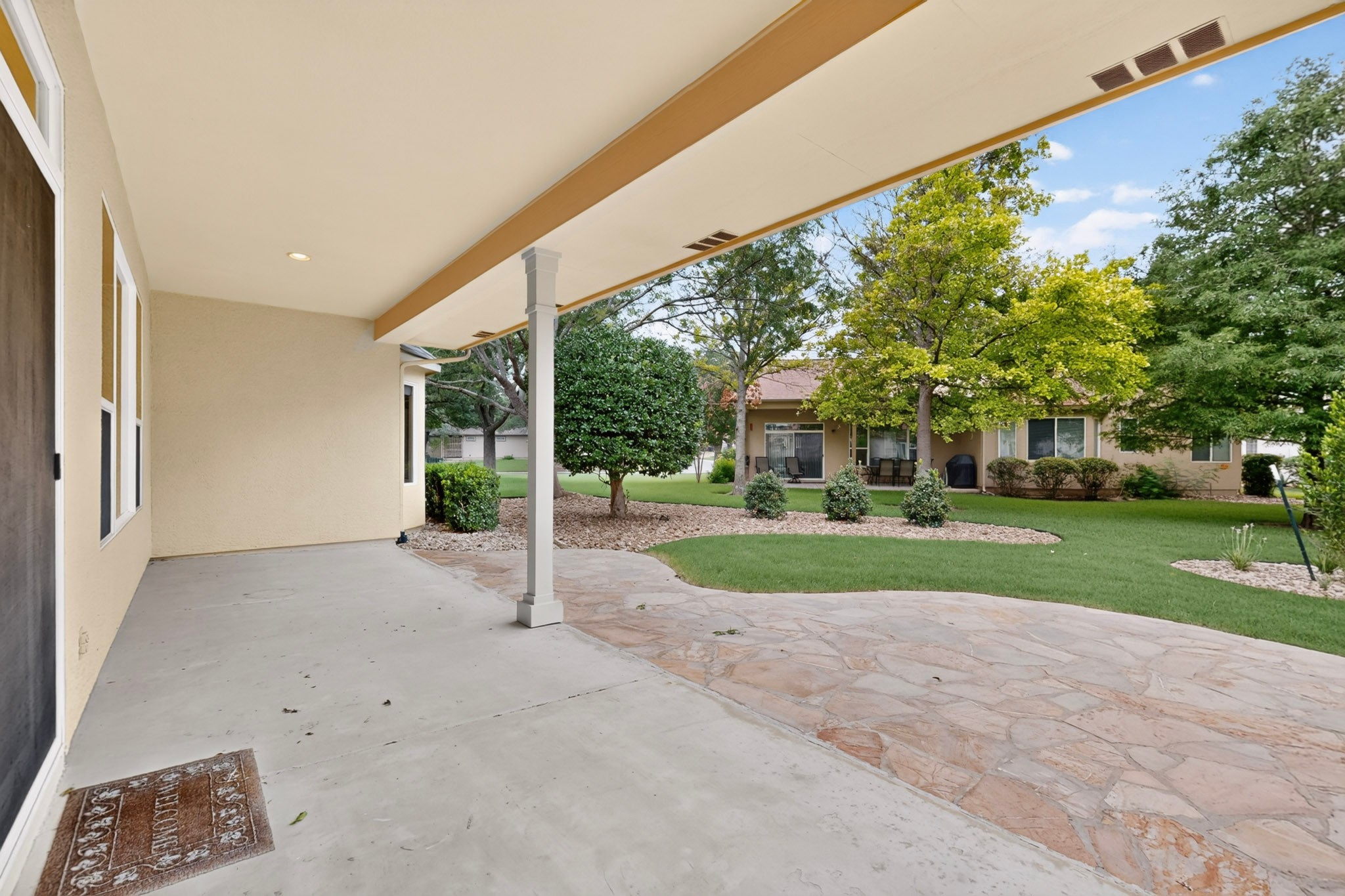 207 Red Poppy Trail Georgetown, TX 78633 - Photo 26 of 31 Spacious covered patio transitions to a lush lawn and an inviting stone-paved area.
