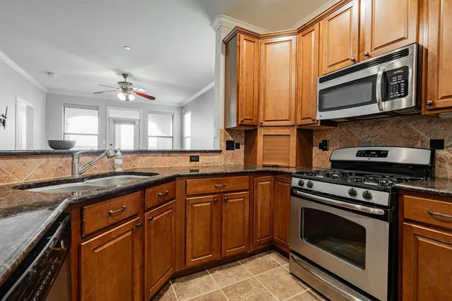 a kitchen with stainless steel appliances granite countertop a stove microwave and sink