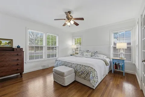 a spacious bedroom with a bed and wooden floor