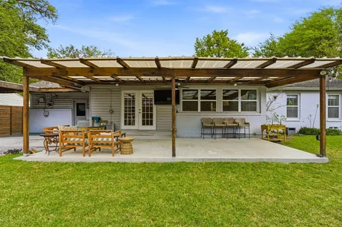 a view of a chair and table in backyard of the house