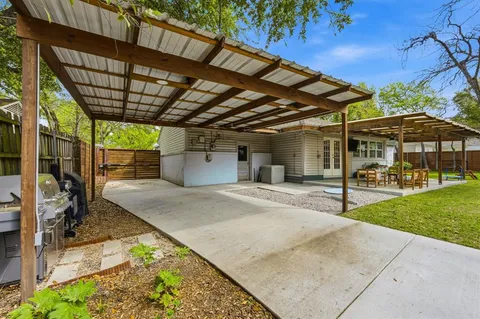 a view of a backyard with wooden fence and a porch