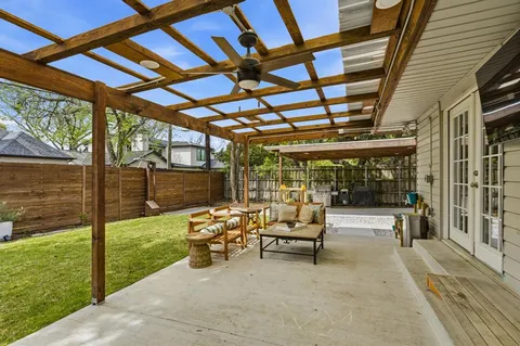 a view of a patio with table and chairs and floor to ceiling window