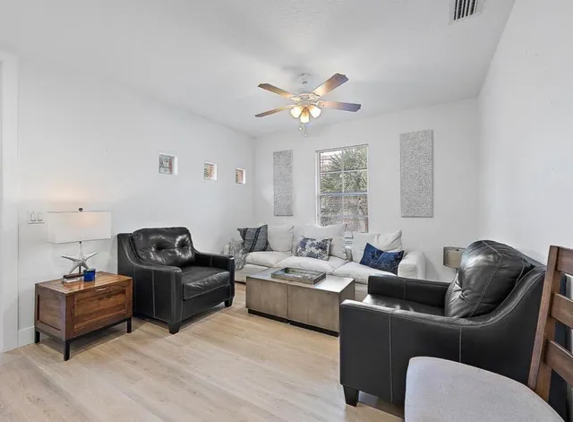 a living room with furniture ceiling fan and a window