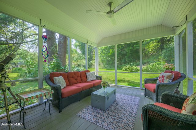 a view of a patio with couches chairs potted plants and a yard
