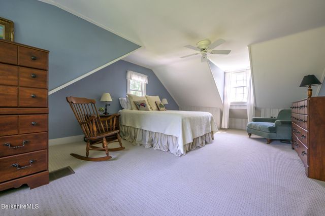 a spacious bedroom with a bed a desk and chair