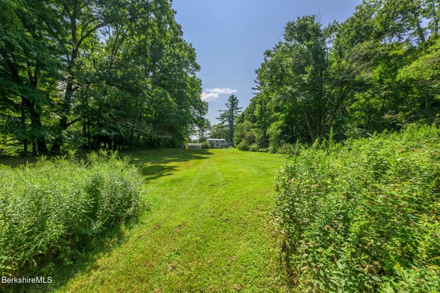 a view of green field with trees in the background