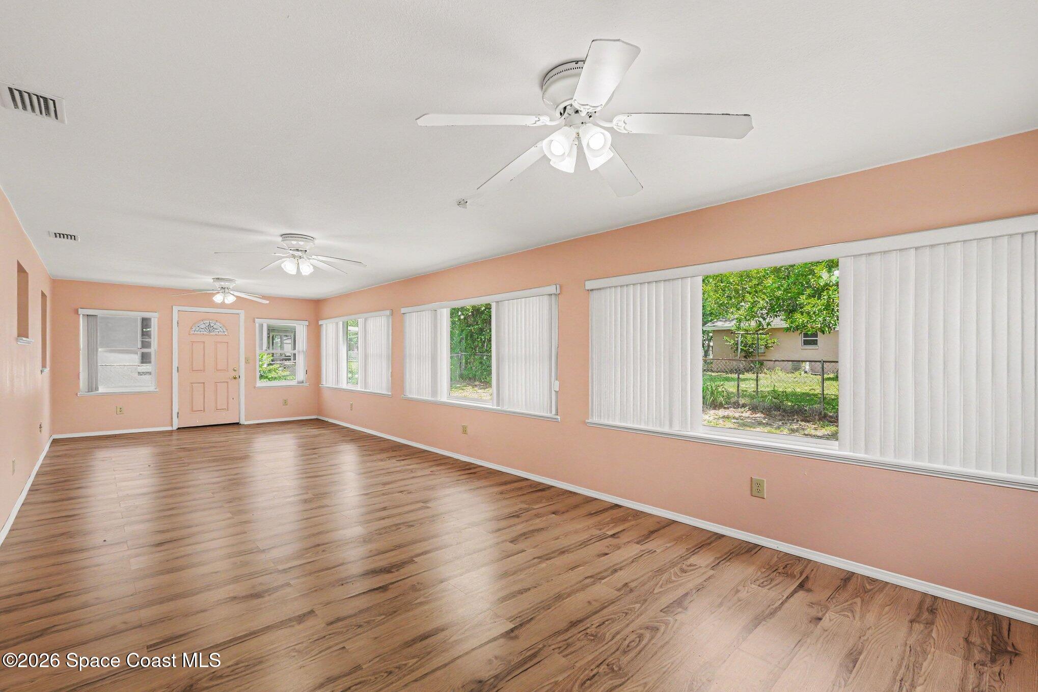 1671 Rice Avenue Titusville, FL 32796 - Photo 11 of 23 a view of an empty room with wooden floor and a window