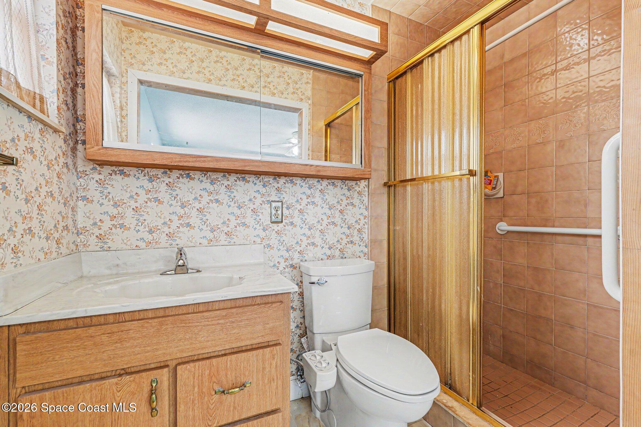 1671 Rice Avenue Titusville, FL 32796 - Photo 15 of 23 a bathroom with a sink a toilet and shower