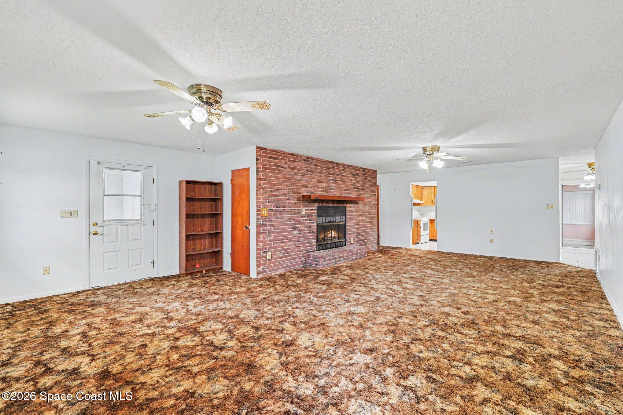1671 Rice Avenue Titusville, FL 32796 - Photo 4 of 23 a view of a livingroom with a ceiling fan closet and a ceiling fan