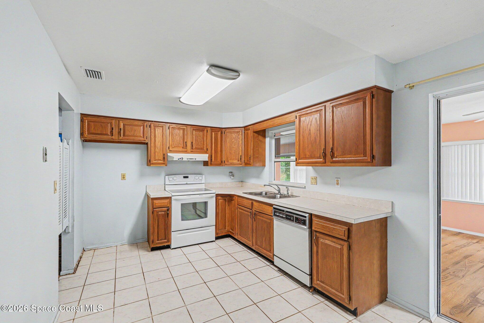 1671 Rice Avenue Titusville, FL 32796 - Photo 8 of 23 a kitchen with stainless steel appliances granite countertop a stove sink and cabinets