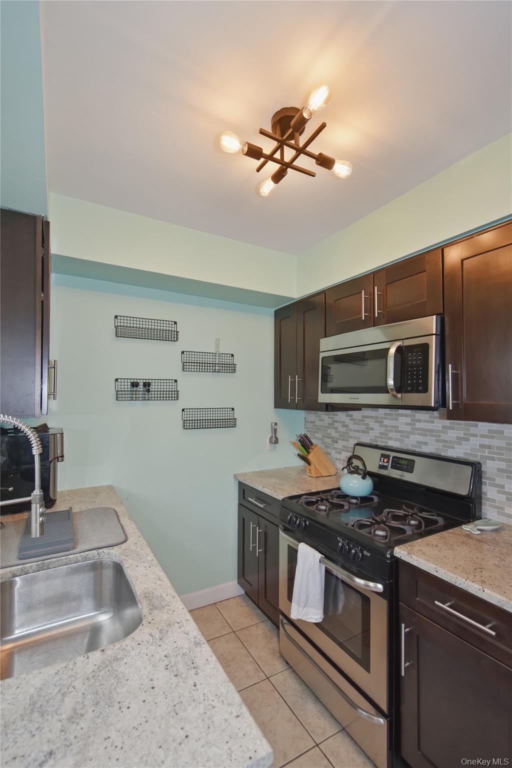 737 Tuckahoe Road, Unit 23 Yonkers, NY 10710 - Photo 11 of 13 a kitchen with stainless steel appliances granite countertop a sink and a stove