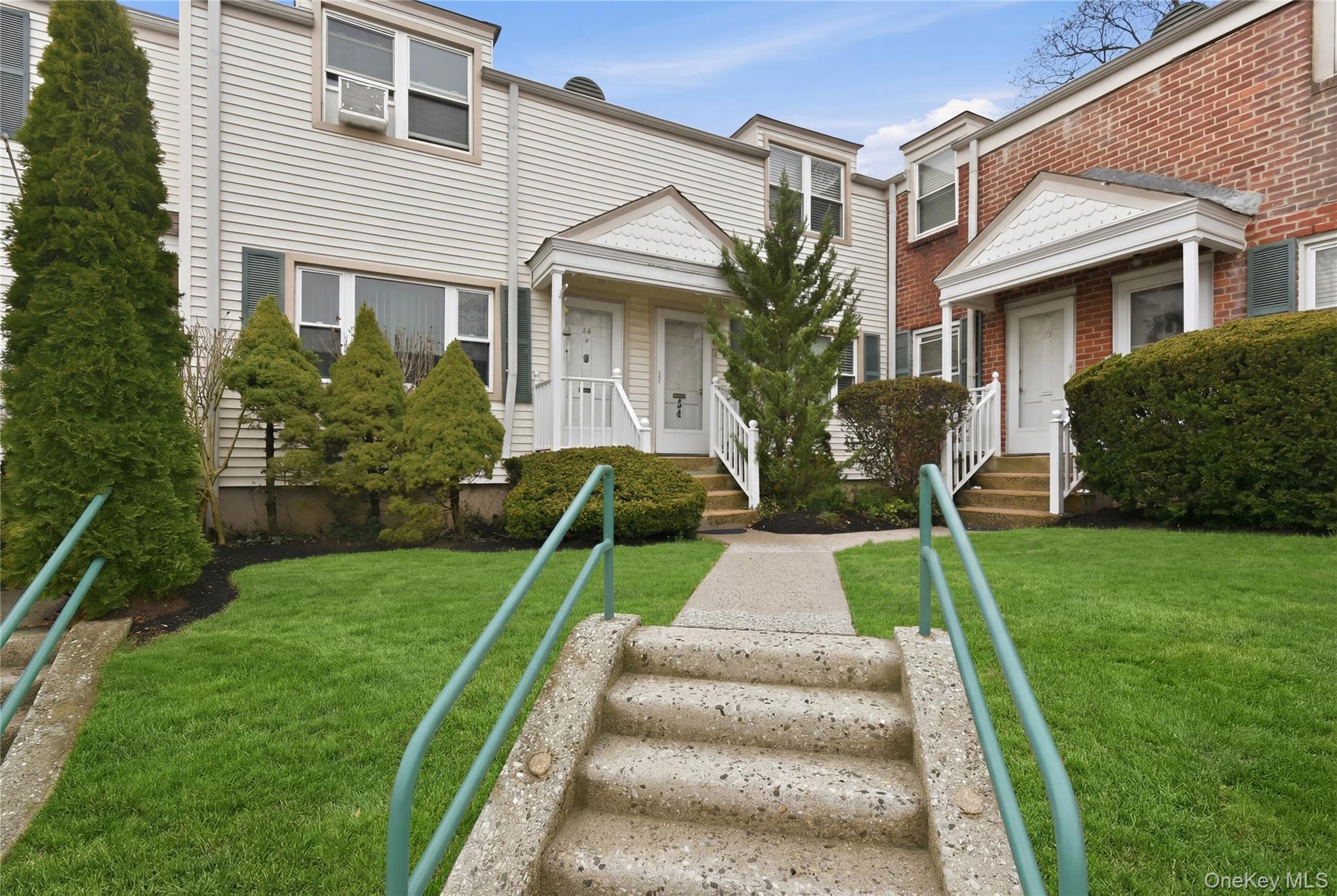 737 Tuckahoe Road, Unit 23 Yonkers, NY 10710 - Photo 2 of 13 a view of a white house next to a yard with big trees