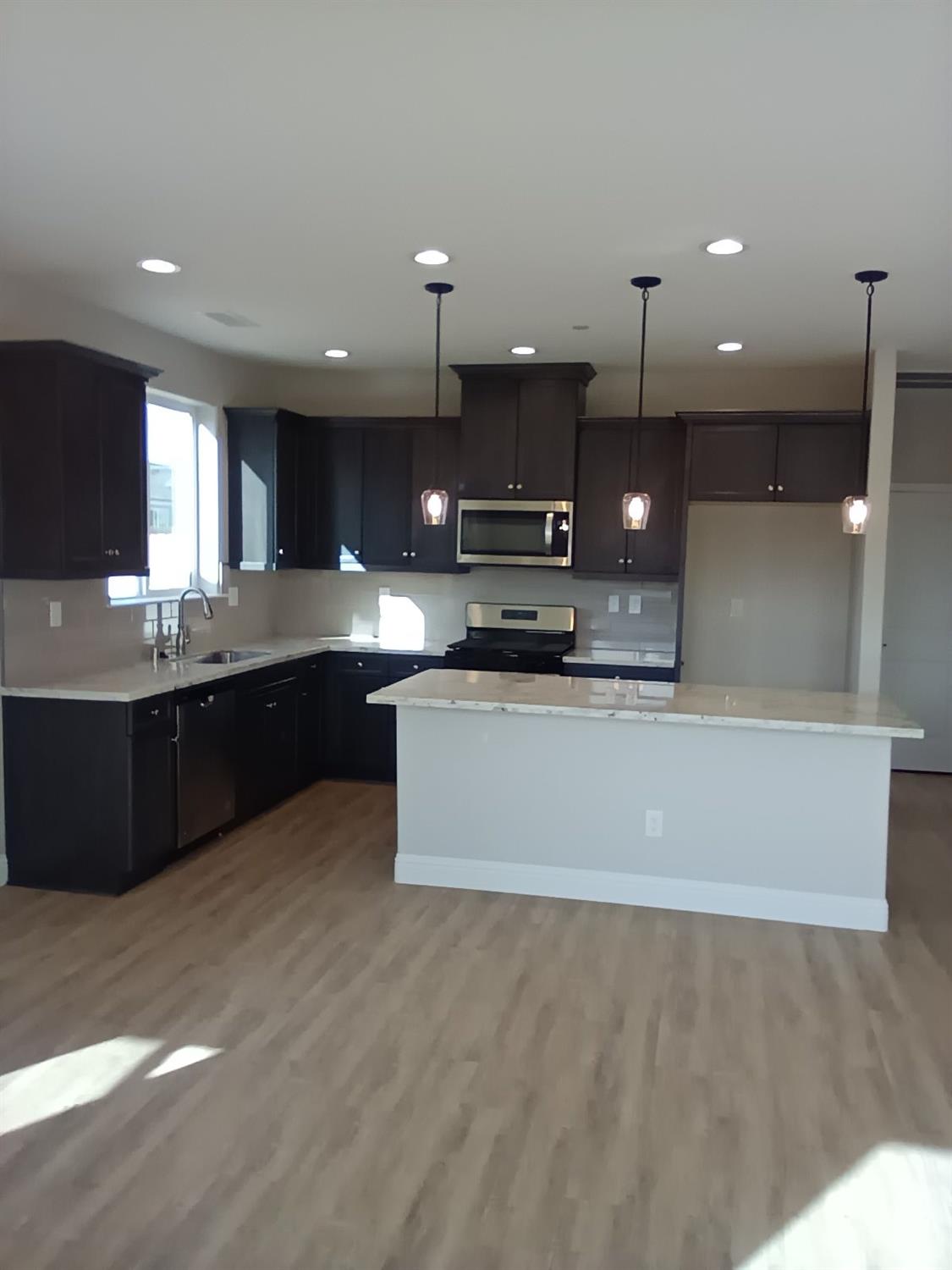 a large kitchen with stainless steel appliances kitchen island a large counter top and a stove