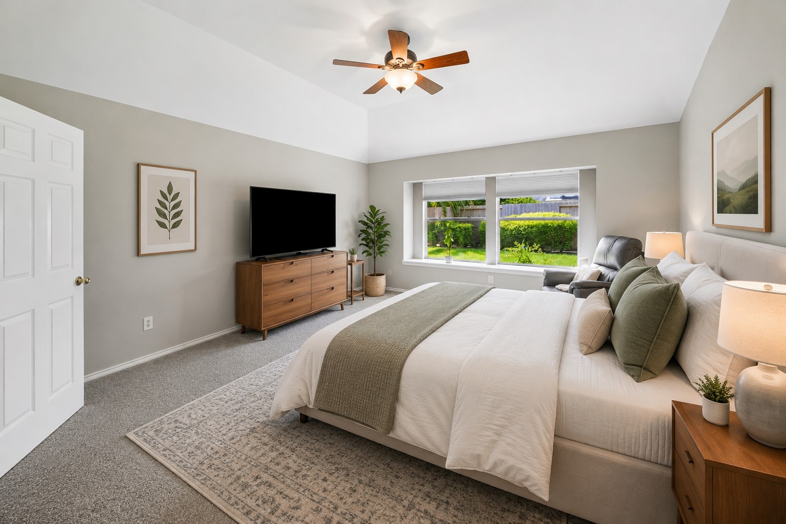 3118 Valley Court Manvel, TX 77578 - Photo 12 of 38 This bright, virtual staged spacious bedroom features a large window with garden views, neutral decor, a ceiling fan, and modern furnishings, creating a cozy and inviting atmosphere.