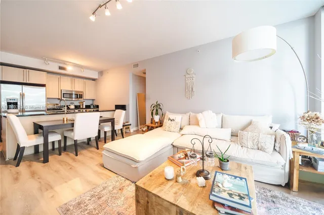 a living room with furniture and a dining table with kitchen view