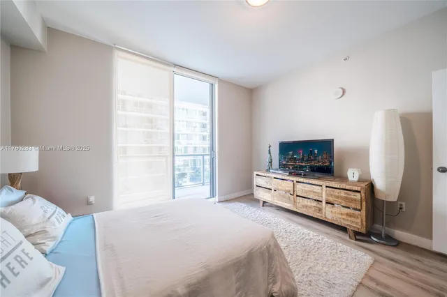 a bedroom with a bed and a flat screen tv