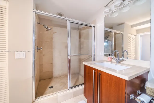 a bathroom with a sink mirror and shower