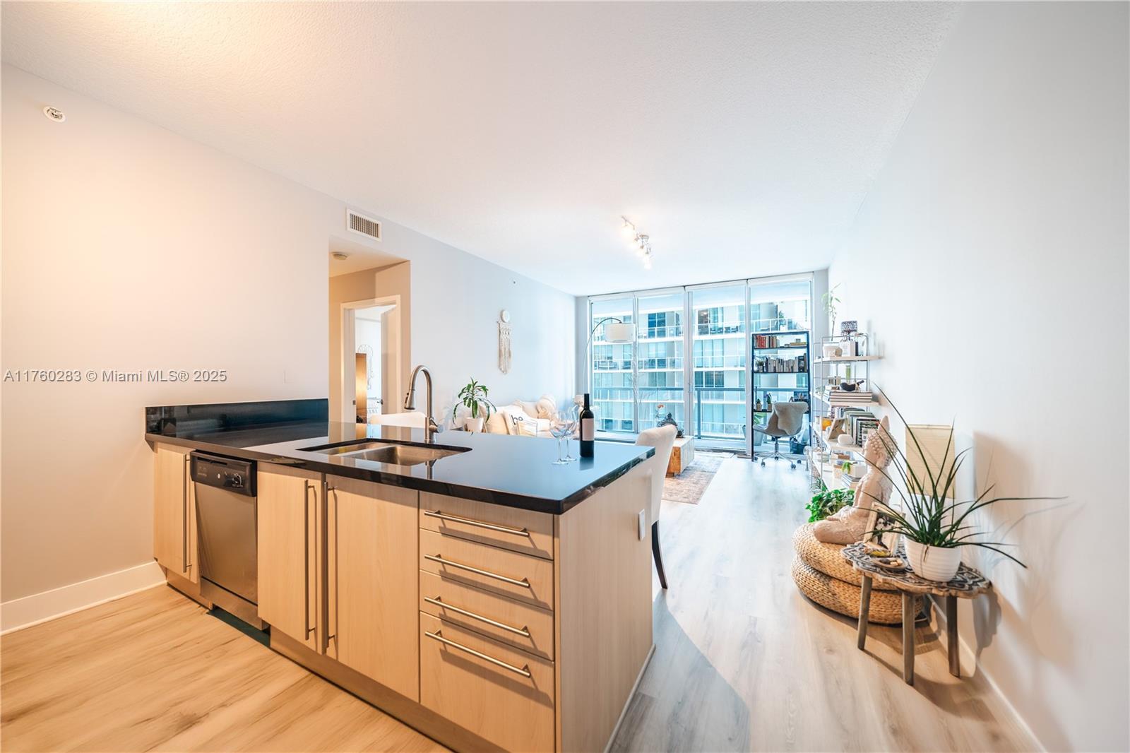 1111 Southwest 1st Avenue, Unit 1115N Miami, FL 33130 - Photo 7 of 27 a kitchen with granite countertop a stove and a wooden floors