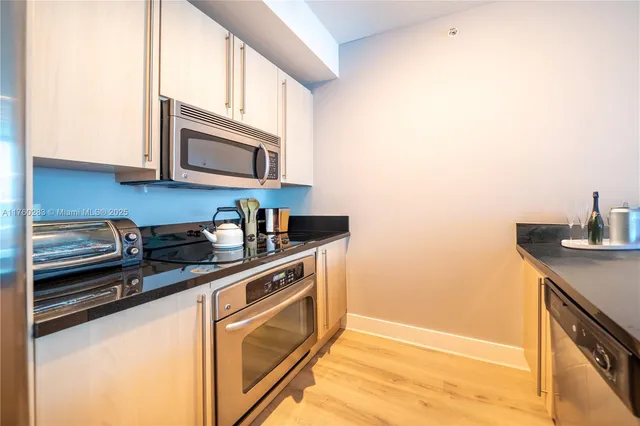 a kitchen with stainless steel appliances granite countertop a sink and a stove