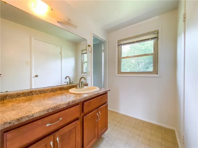 a bathroom with a granite countertop sink and mirror