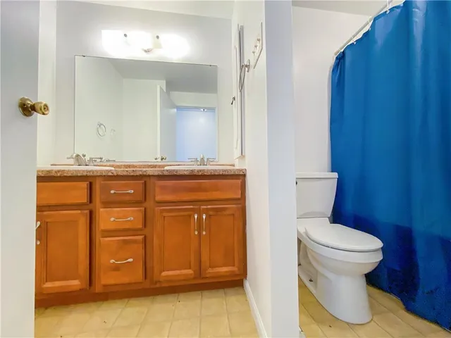 a bathroom with a granite countertop toilet sink and mirror