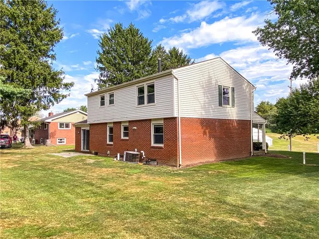 a front view of house with yard and trees