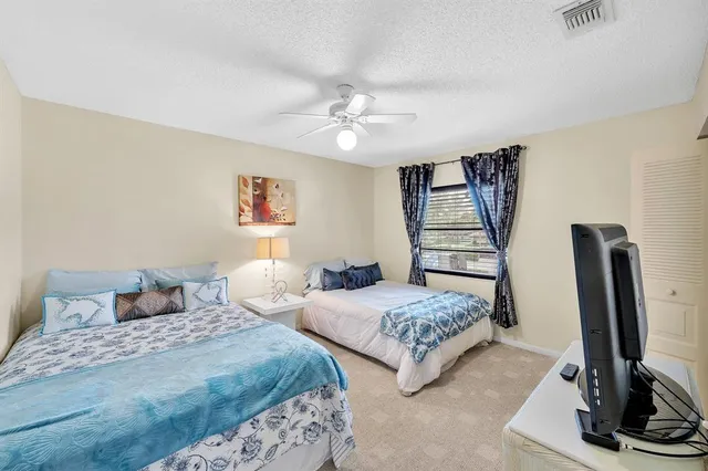 a bedroom with a large bed and a chandelier
