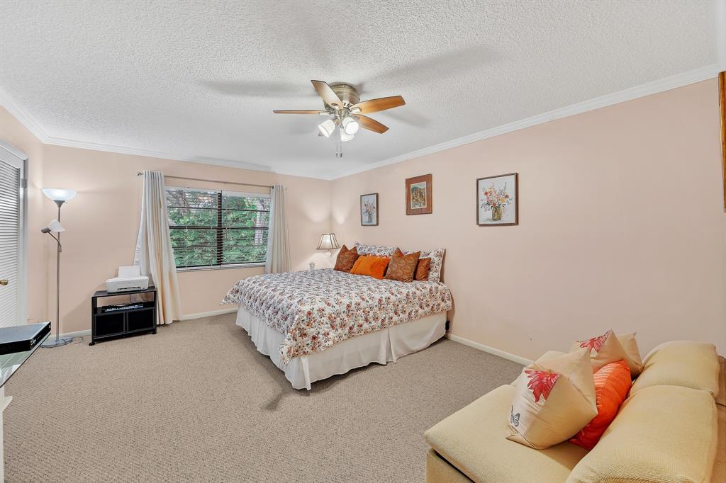 9278 Vista Del Lago, Unit 31F Boca Raton, FL 33428 - Photo 23 of 33 a bedroom with a bed and a couch