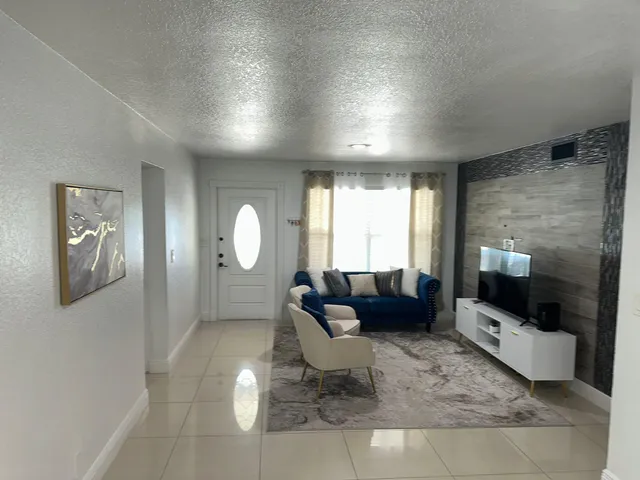 a living room with furniture a large window and a fireplace