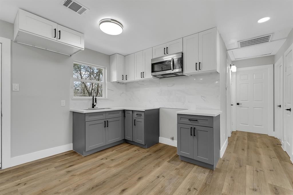 7609 St Lo Road Houston, TX 77033 - Photo 2 of 14 a kitchen with stainless steel appliances a sink cabinets and wooden floor