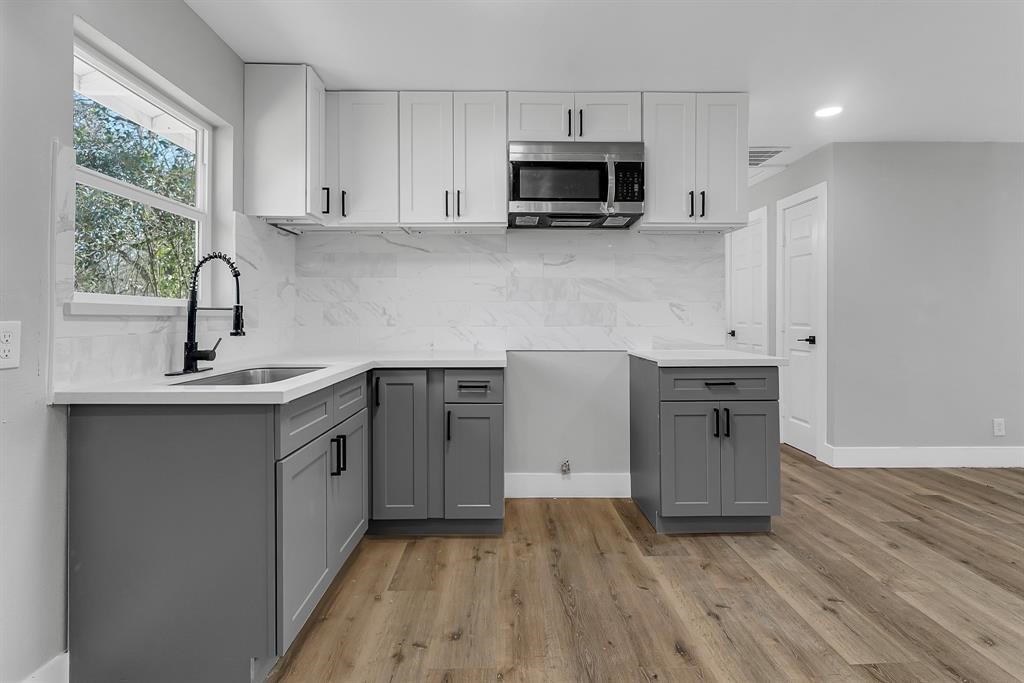 7609 St Lo Road Houston, TX 77033 - Photo 7 of 14 a kitchen with stainless steel appliances a sink a stove a refrigerator cabinets and a window