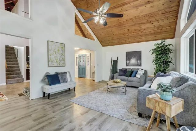 a living room with furniture a flat screen tv and a large window
