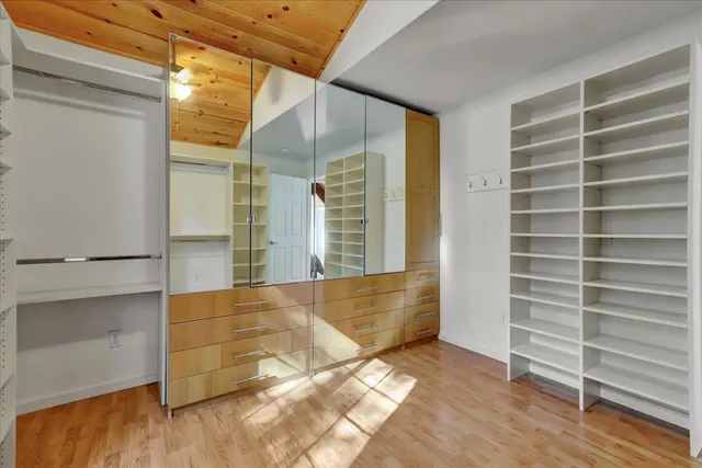 an empty room with a fan & a chandelier fan