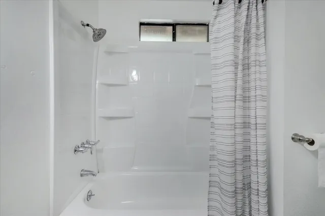 a view of swimming pool with lawn chairs and plants