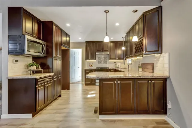 a view of a dining room with furniture a chandelier and large windows