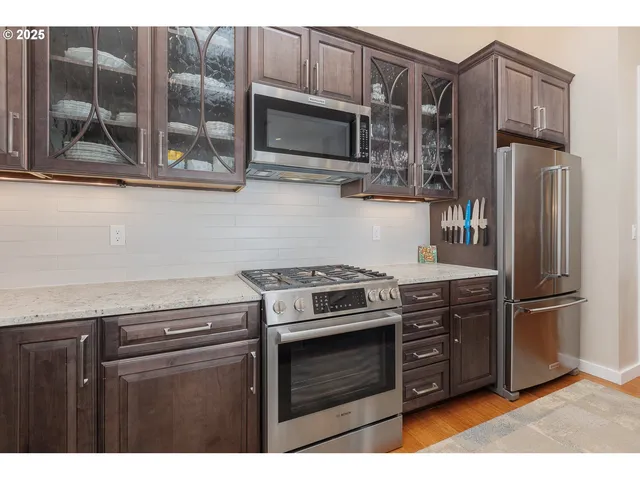 a kitchen with stainless steel appliances granite countertop a stove microwave and refrigerator
