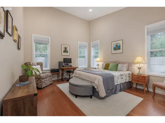 a spacious bedroom with a bed a table and chair