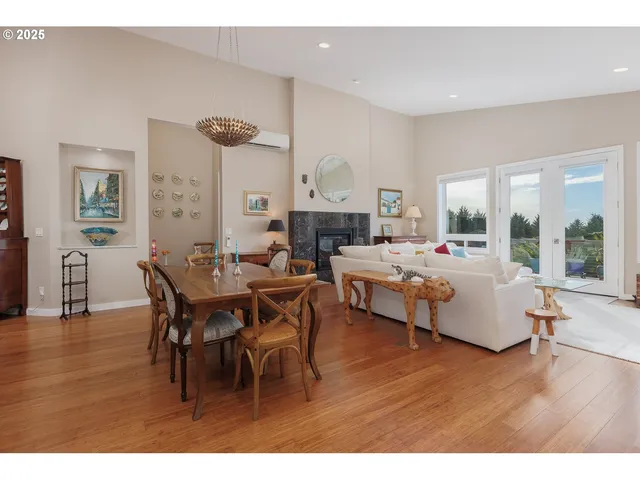 a living room with furniture dining table a fireplace and a view of kitchen