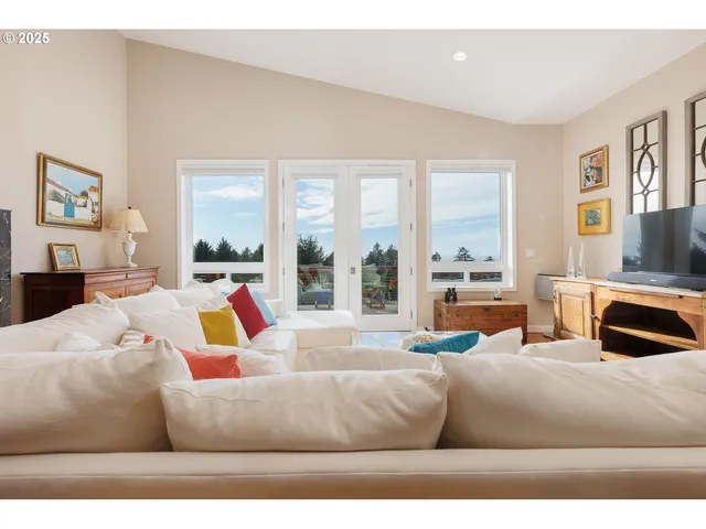 a living room with furniture wooden floor and a large window