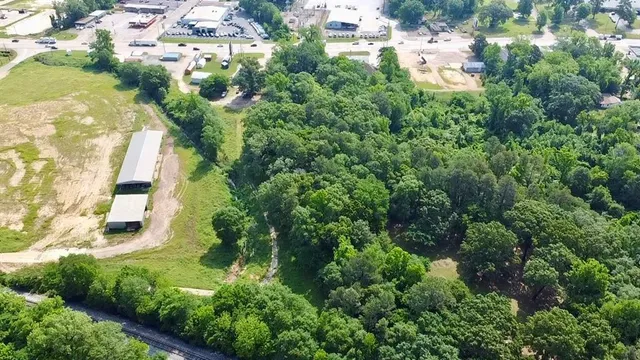 an aerial view of residential houses with outdoor space and trees