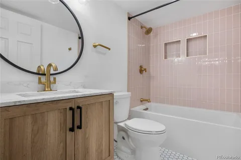 a bathroom with a toilet sink a mirror and vanity