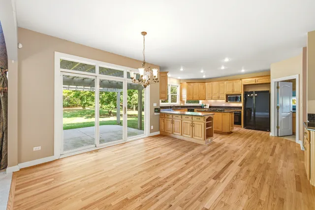 a view of an empty room with chandelier fan and fire place