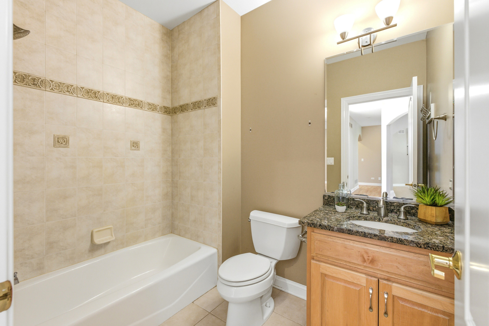 37-w004 Ridgewood Drive St. Charles, IL 60175 - Photo 28 of 44 a bathroom with a granite countertop toilet a sink and a bathtub