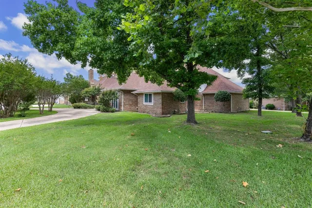 a front view of a house with yard and green space